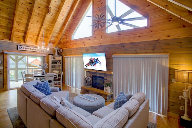 living room with beamed ceiling, wooden ceiling, wooden walls, and light hardwood / wood-style flooring