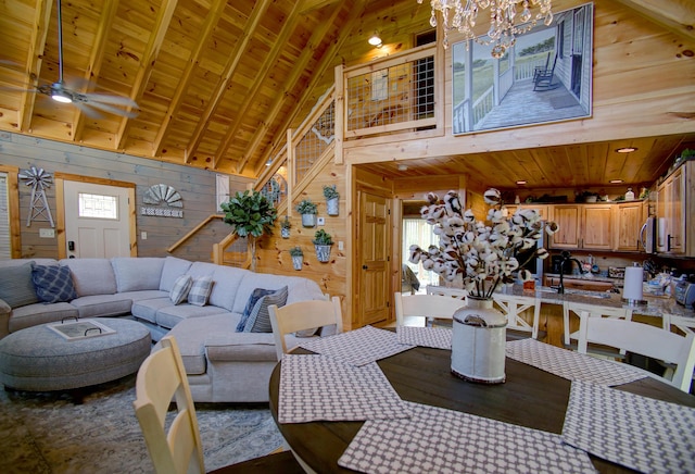 dining room with beam ceiling, high vaulted ceiling, wooden walls, and wood ceiling