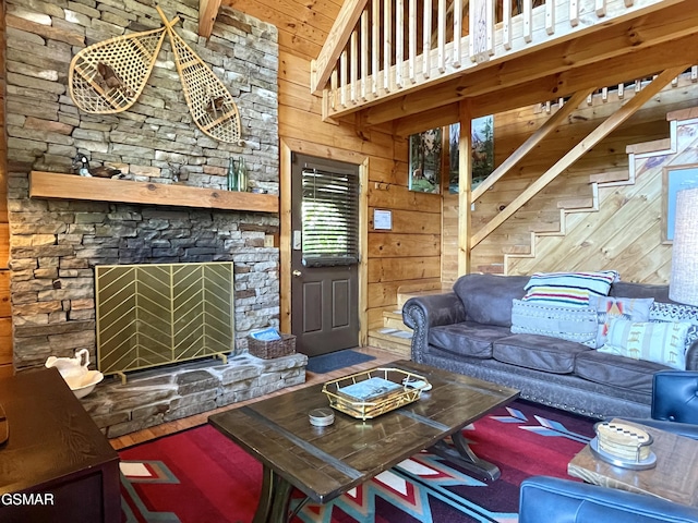 910 Laurel Lick Rd, Pigeon Forge, TN 37863 - living area featuring wooden walls, high vaulted ceiling, stairs, and a stone fireplace