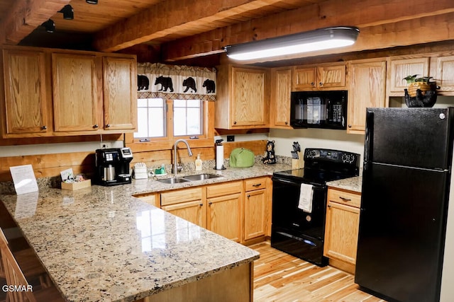 kitchen featuring a sink, light wood-style floors, beamed ceiling, a peninsula, and black appliances