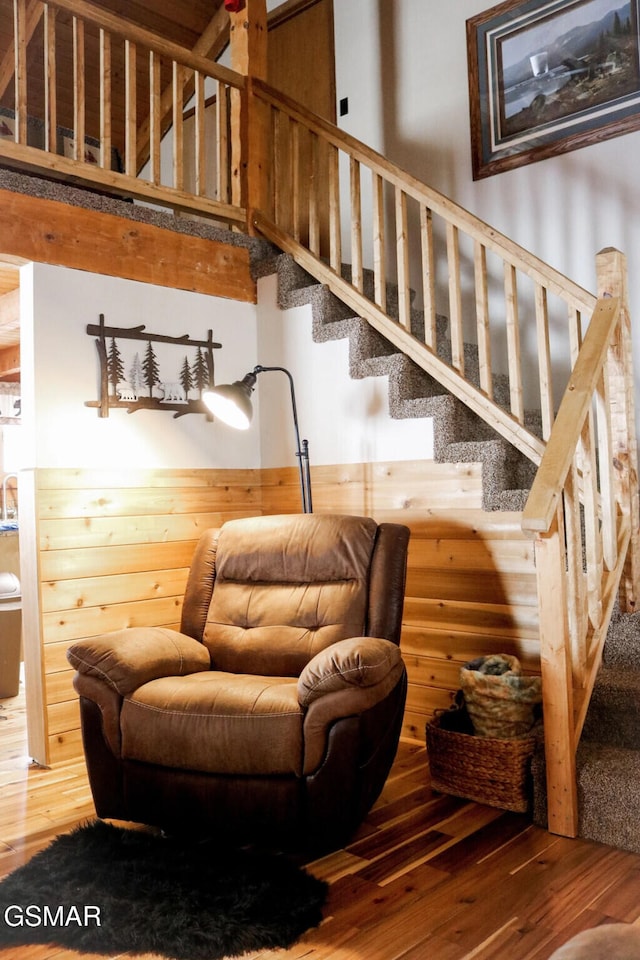 stairs featuring a high ceiling and wood finished floors