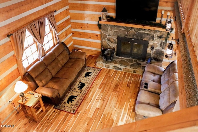 living area featuring a fireplace, wood finished floors, and wooden walls