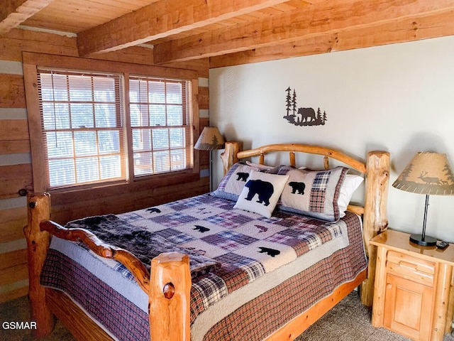 bedroom with carpet floors and beamed ceiling