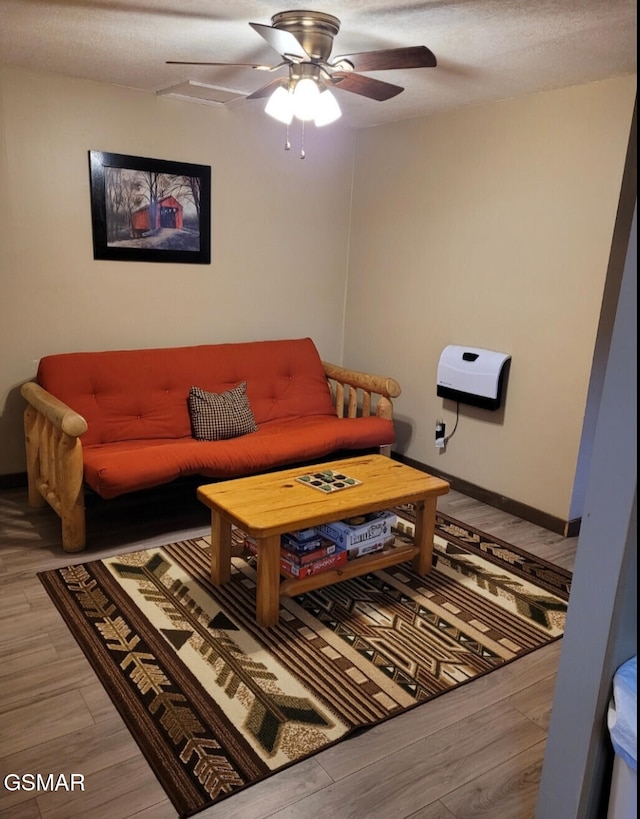living area with light wood finished floors, baseboards, and ceiling fan