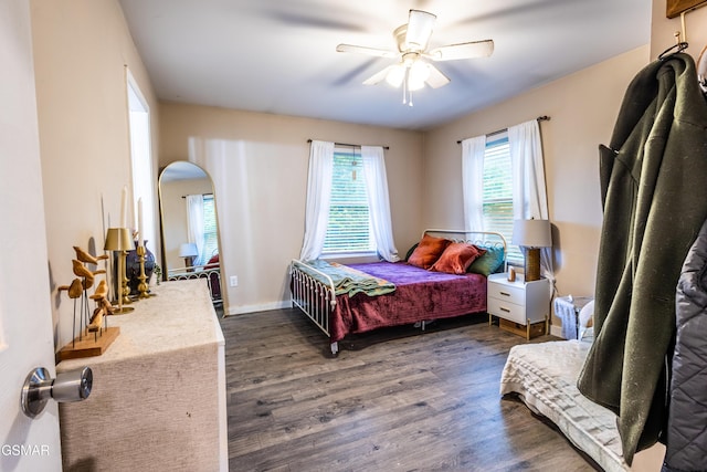 bedroom featuring dark wood-style floors, arched walkways, and a ceiling fan
