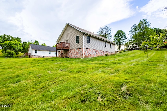 view of side of home with a lawn and a wooden deck