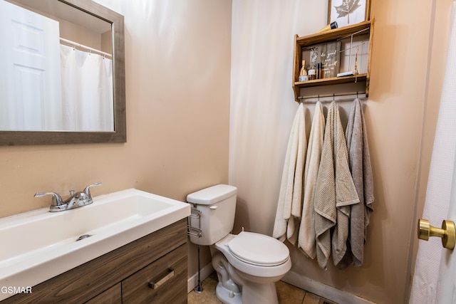 bathroom featuring toilet, vanity, and tile patterned flooring
