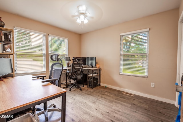 home office with a ceiling fan, wood finished floors, and baseboards