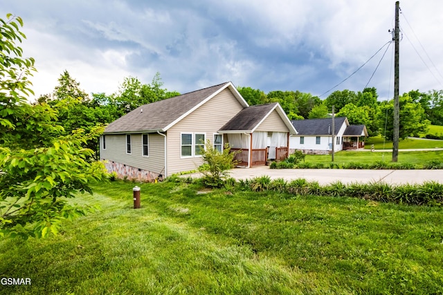 ranch-style house featuring a shingled roof, concrete driveway, and a front yard