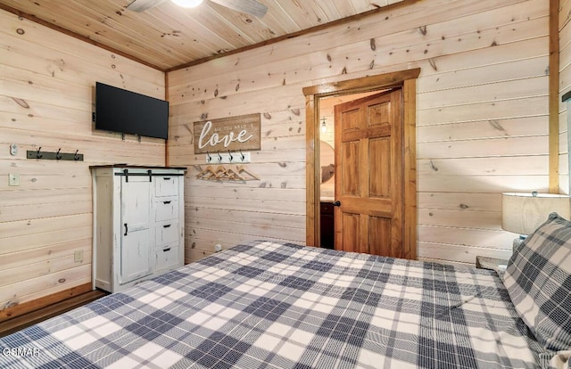 unfurnished bedroom featuring wood walls, ceiling fan, a barn door, and wood ceiling