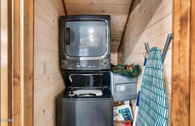 clothes washing area with wood walls, wood ceiling, and stacked washer / dryer