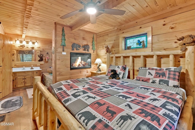 bedroom featuring ceiling fan, wooden ceiling, beamed ceiling, light hardwood / wood-style floors, and wooden walls