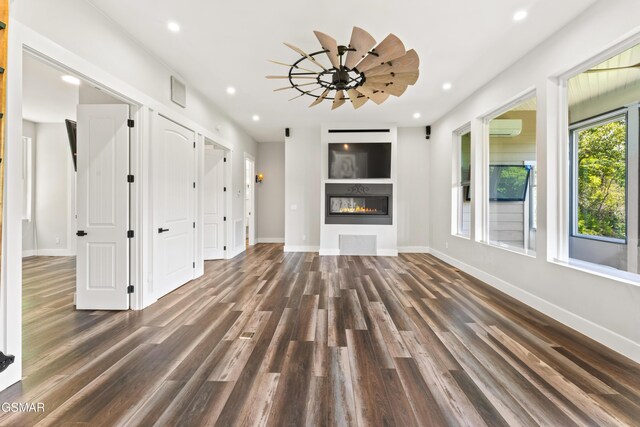 3955 Denton Ct, Sevierville, TN 37862 - unfurnished living room featuring dark wood-type flooring, recessed lighting, a glass covered fireplace, and an AC wall unit