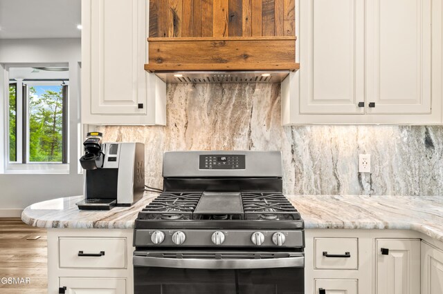 3955 Denton Ct, Sevierville, TN 37862 - kitchen featuring gas range, white cabinets, wood finished floors, and tasteful backsplash