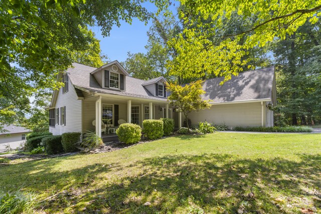 cape cod house with covered porch and a front yard