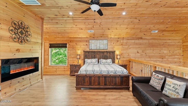 438 Alpine Mountain Way, Pigeon Forge, TN 37863 - bedroom featuring wooden ceiling, wooden walls, wood finished floors, and a glass covered fireplace