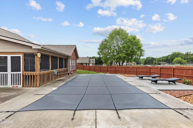 view of swimming pool featuring fence, a patio, and a sunroom