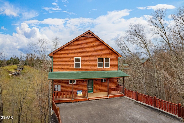 back of property with a porch and driveway