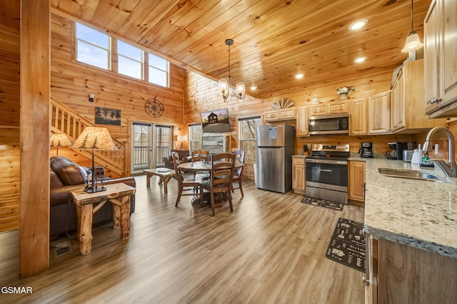 692 Stockton Dr, Sevierville, TN 37876 - kitchen featuring stainless steel appliances, a sink, wooden ceiling, wooden walls, and light wood finished floors