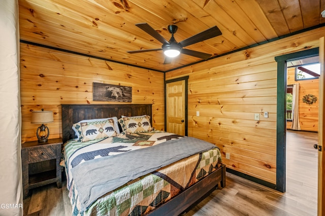 bedroom with hardwood / wood-style floors, ceiling fan, wooden ceiling, and wood walls