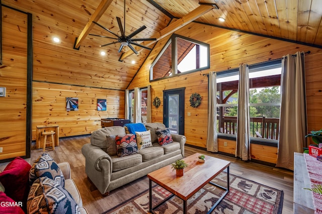 living room featuring hardwood / wood-style flooring, wood walls, wood ceiling, and beamed ceiling