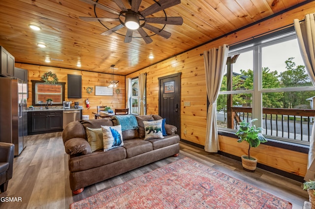 living room with hardwood / wood-style flooring, ceiling fan, wood walls, and wood ceiling