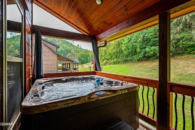 wooden deck with a lawn and a hot tub