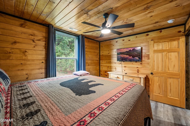 bedroom featuring hardwood / wood-style floors, ceiling fan, wooden walls, and wood ceiling