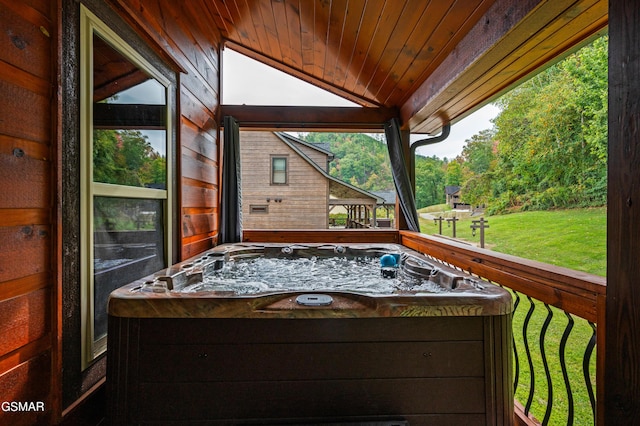 wooden deck with a hot tub and a lawn