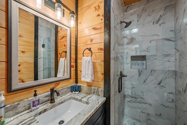 bathroom featuring vanity, walk in shower, and wooden walls