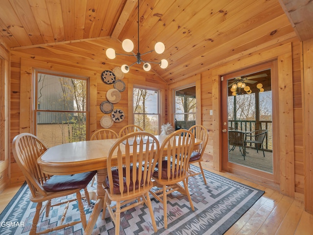 dining room featuring vaulted ceiling, wood ceiling, an inviting chandelier, light wood-style flooring, and wood walls