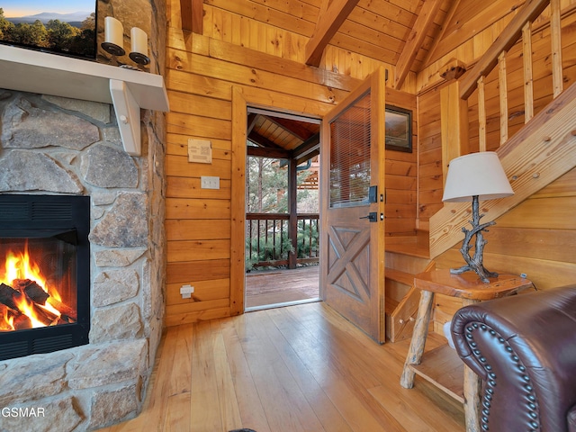 entrance foyer with wooden walls, vaulted ceiling with beams, and wood ceiling