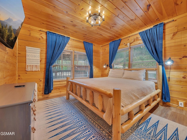 bedroom featuring wood finished floors, wood walls, wood ceiling, and multiple windows