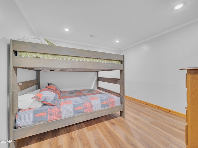 bedroom featuring baseboards, crown molding, wood finished floors, and recessed lighting