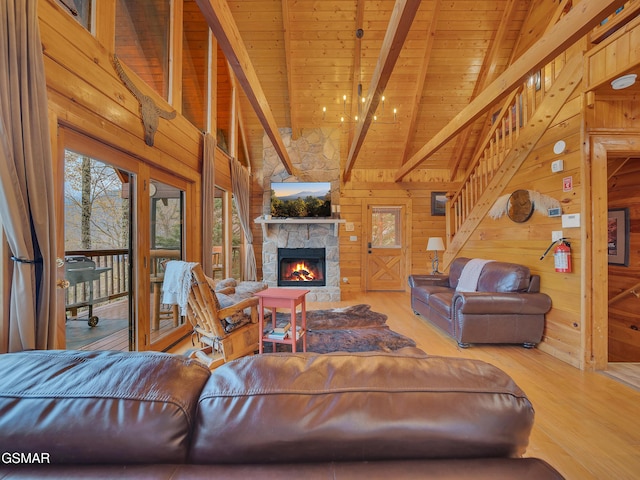 living room with wood walls, wood finished floors, beamed ceiling, wood ceiling, and a fireplace