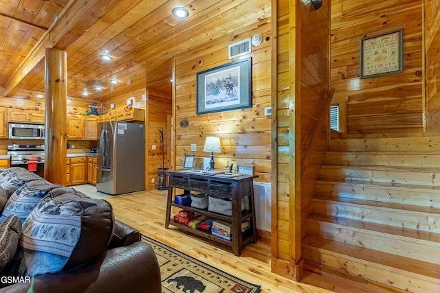 living room featuring wood walls, light hardwood / wood-style floors, and wooden ceiling