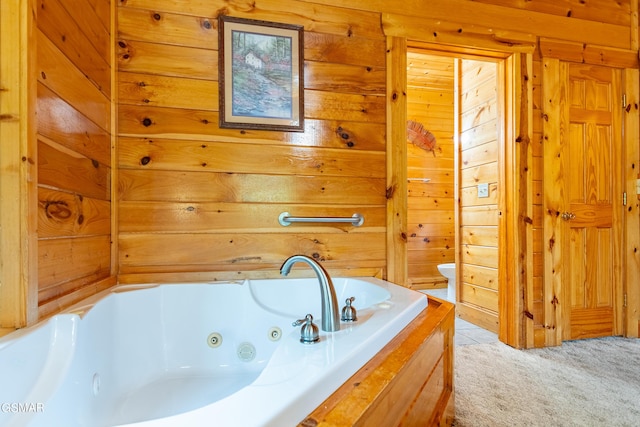 bathroom featuring a bathing tub, wooden walls, and toilet