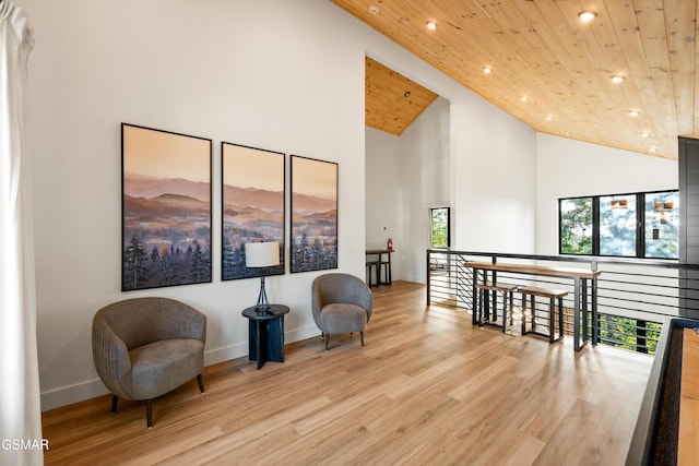 living area with wood ceiling, high vaulted ceiling, recessed lighting, light wood finished floors, and baseboards