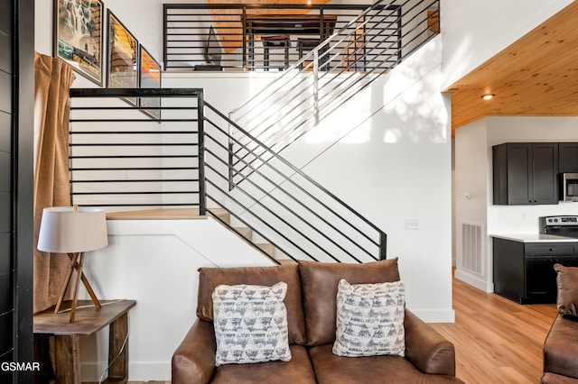 stairs featuring wood finished floors, baseboards, and recessed lighting