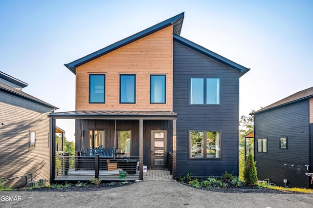 modern home with covered porch and board and batten siding
