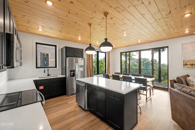 kitchen with a sink, dark cabinets, appliances with stainless steel finishes, wood ceiling, and light wood-style flooring