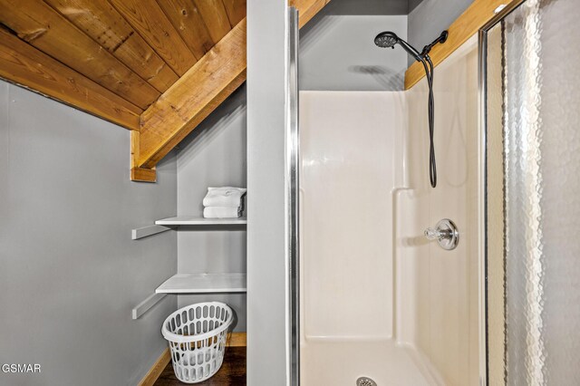 bathroom featuring walk in shower and wood ceiling