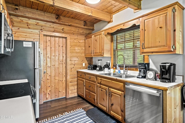 kitchen with appliances with stainless steel finishes, wooden walls, sink, beamed ceiling, and dark hardwood / wood-style floors