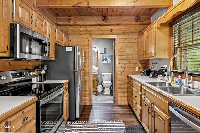 kitchen with wood walls, sink, wooden ceiling, and stainless steel appliances