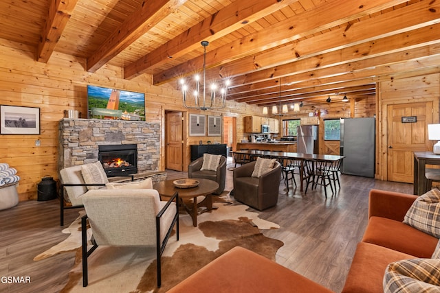 living room with hardwood / wood-style flooring, beam ceiling, wood ceiling, a fireplace, and wooden walls