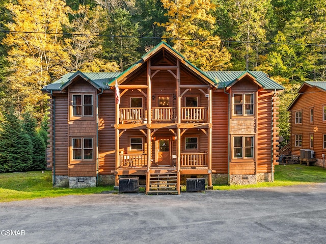 log cabin featuring a balcony, central AC unit, and covered porch