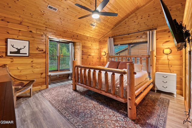 bedroom with ceiling fan, light wood-type flooring, wood ceiling, wood walls, and lofted ceiling