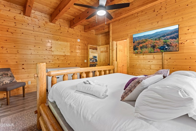 bedroom with ceiling fan, wood ceiling, hardwood / wood-style floors, wooden walls, and beamed ceiling