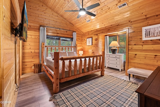 bedroom featuring wood-type flooring, ceiling fan, wooden ceiling, wooden walls, and lofted ceiling