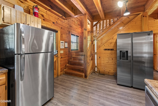 kitchen with appliances with stainless steel finishes and wood walls